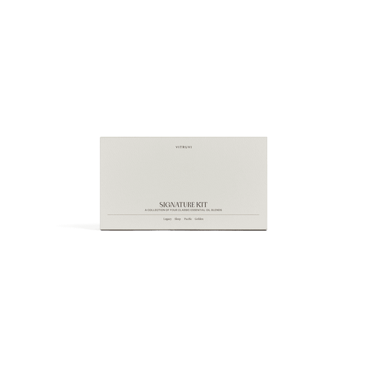 Four Vitruvi essential oil bottles labeled 'Legacy', 'Sleep', 'Pacify', and 'Gold' on a green background.