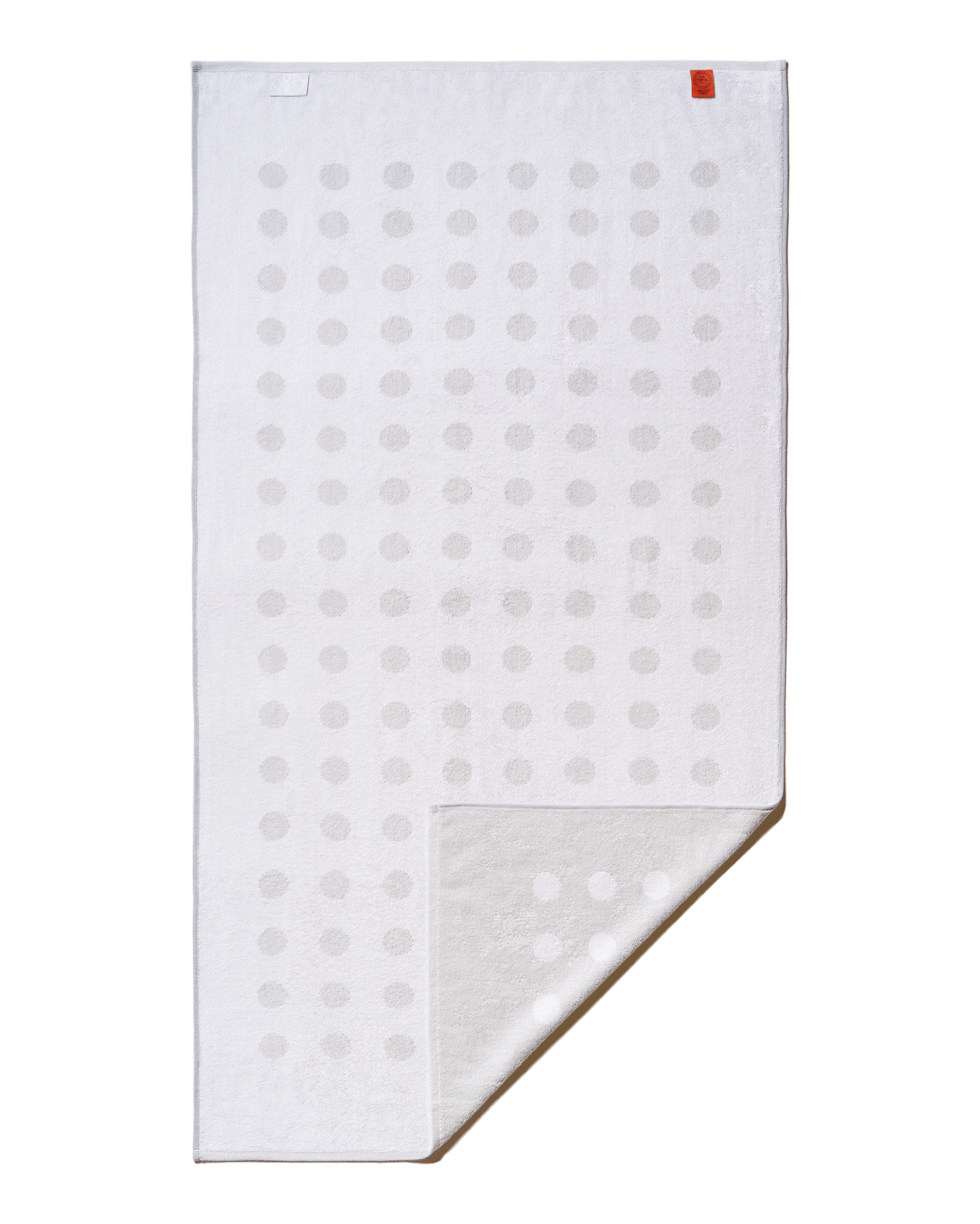 White towel with gray polka dots on a black background