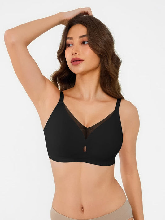 Woman wearing a black bralette against a plain background