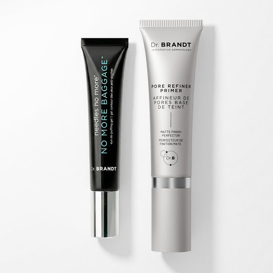 Two Dr. Brandt skincare tubes on a clean white background: a matte black No More Baggage tube with a silver cap next to a silver Pore Refiner Primer tube with a white cap.