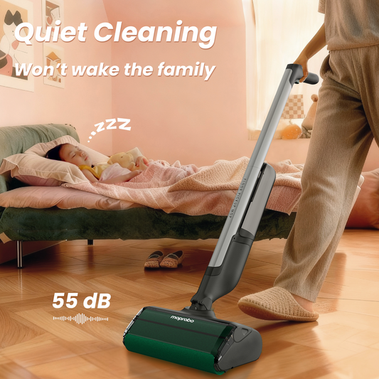 Person using a vacuum cleaner on a wooden floor in a kitchen.
