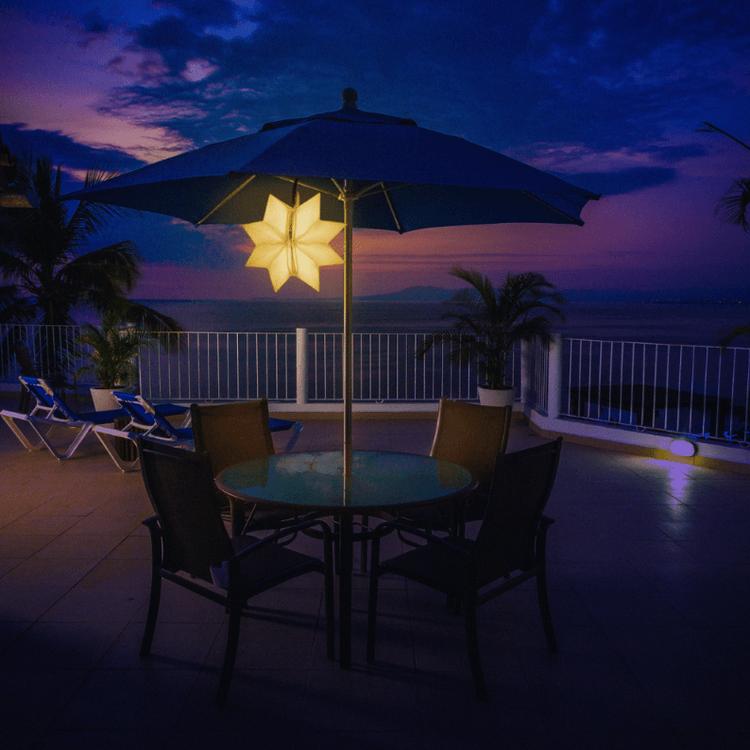 Two QWNN solar lanterns hanging from outdoor umbrella in star shape configuration
