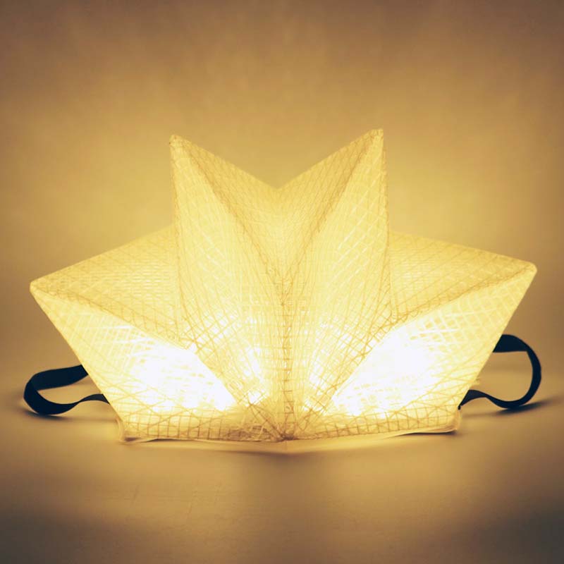 QWNN solar lantern in warm light mode, star crown shape on studio background