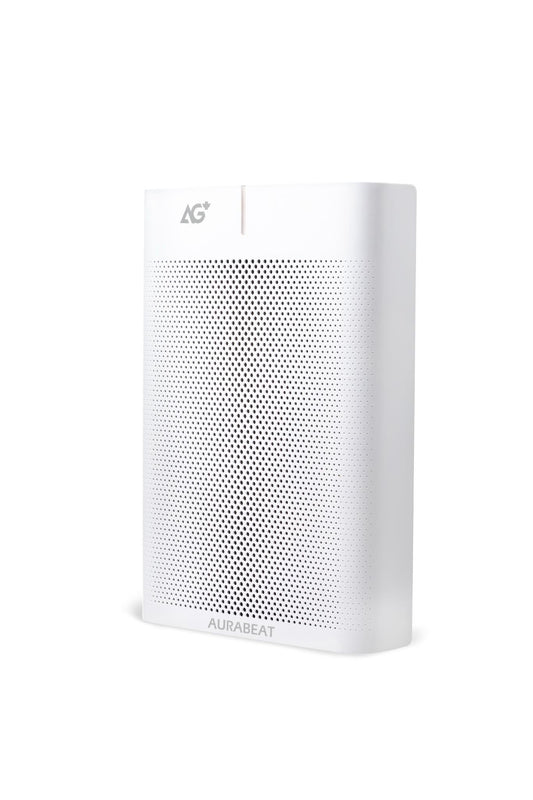 Air purifier on a gray floor with a yellow chair and wooden shelf in the background