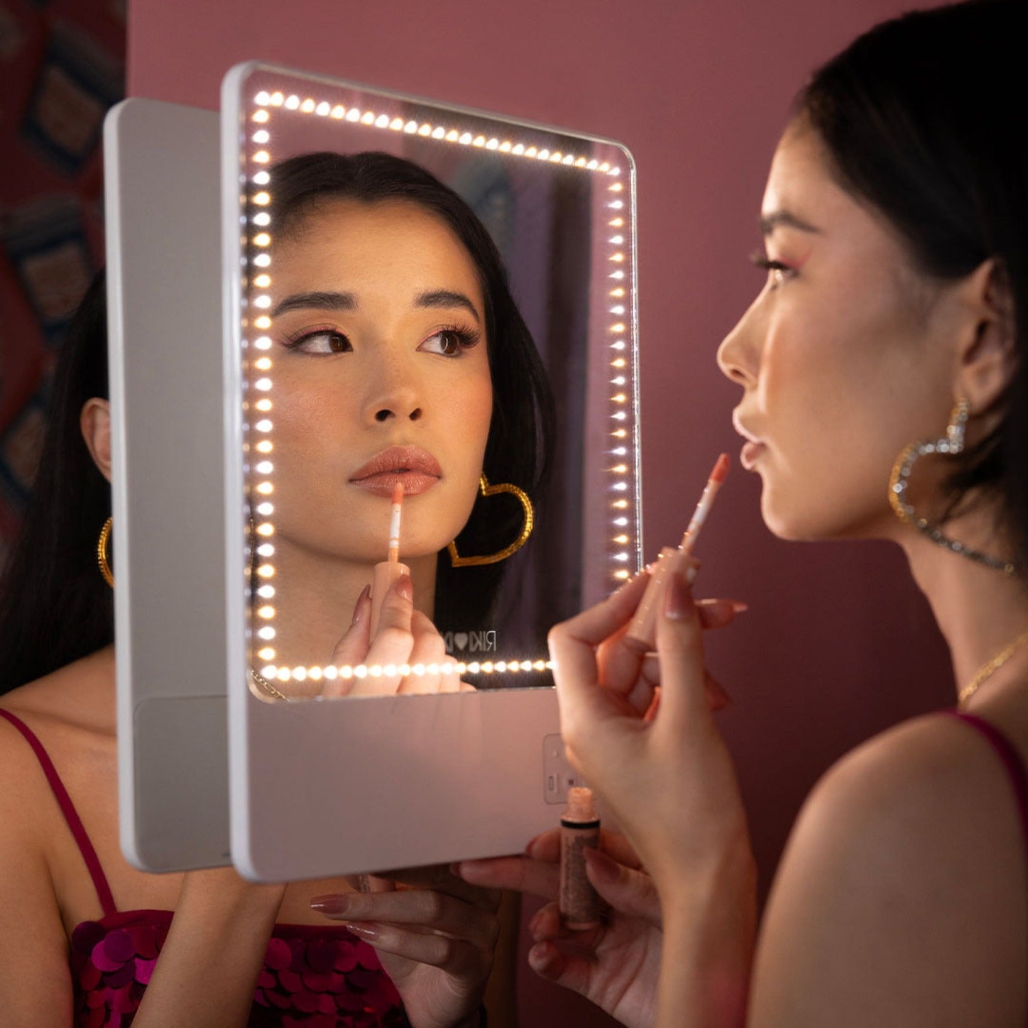 A young woman using RIKI Skinny Duo Makeup Mirror,and  trying its color temperature lights - RIKI LOVES RIKI 