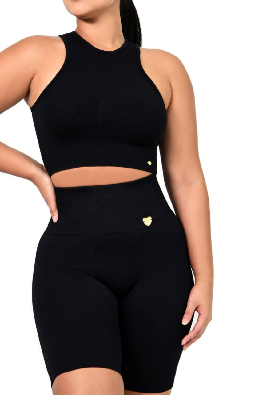 Black athletic outfit with a crop top and high-waisted shorts on a white background