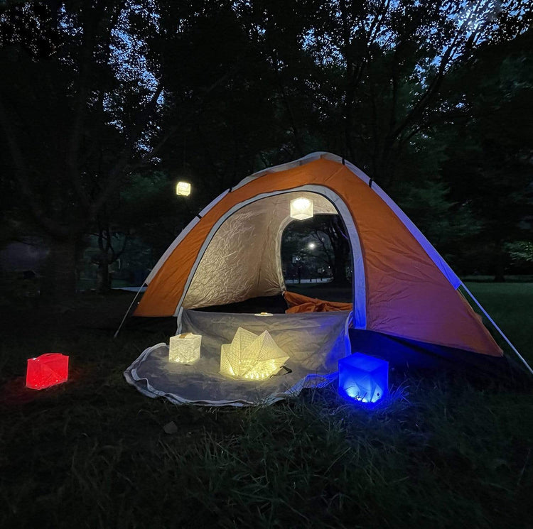 SolarPuff lanterns placed outside tent for eco-friendly camping light