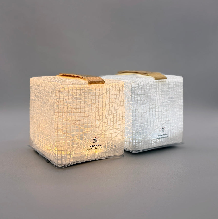Two SolarPuff lanterns in studio, showing warm and bright white hybrid light settings