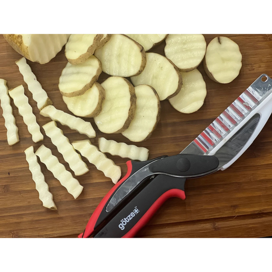 Set of kitchen tools including a peeler, mandoline, and other cutting tools with sliced vegetables on a white background.