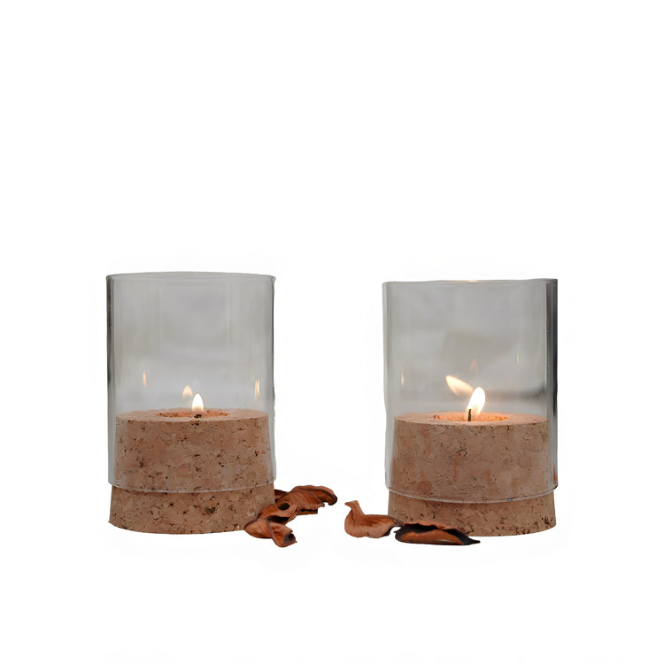 Two candle holders with candles inside on a white background