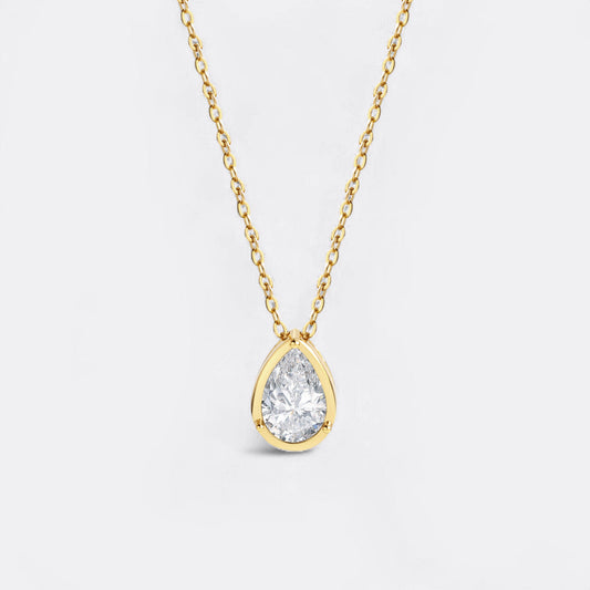 Gold necklace with a teardrop-shaped diamond pendant on a white background