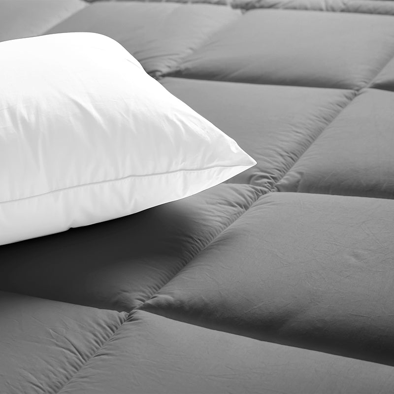 Gray comforter and white pillow on a bed