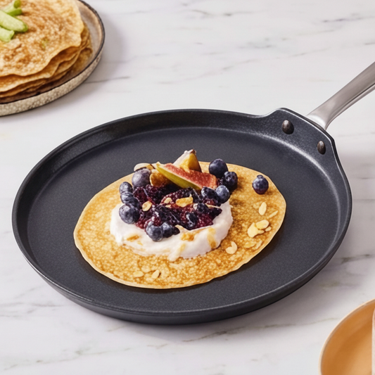 Black frying pan with a silver handle on a white background