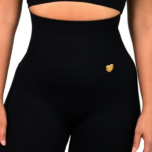 Person wearing a black athletic outfit with a white background