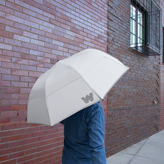 Person walking on sidewalk with Weatherman Collapsible Umbrella in white.