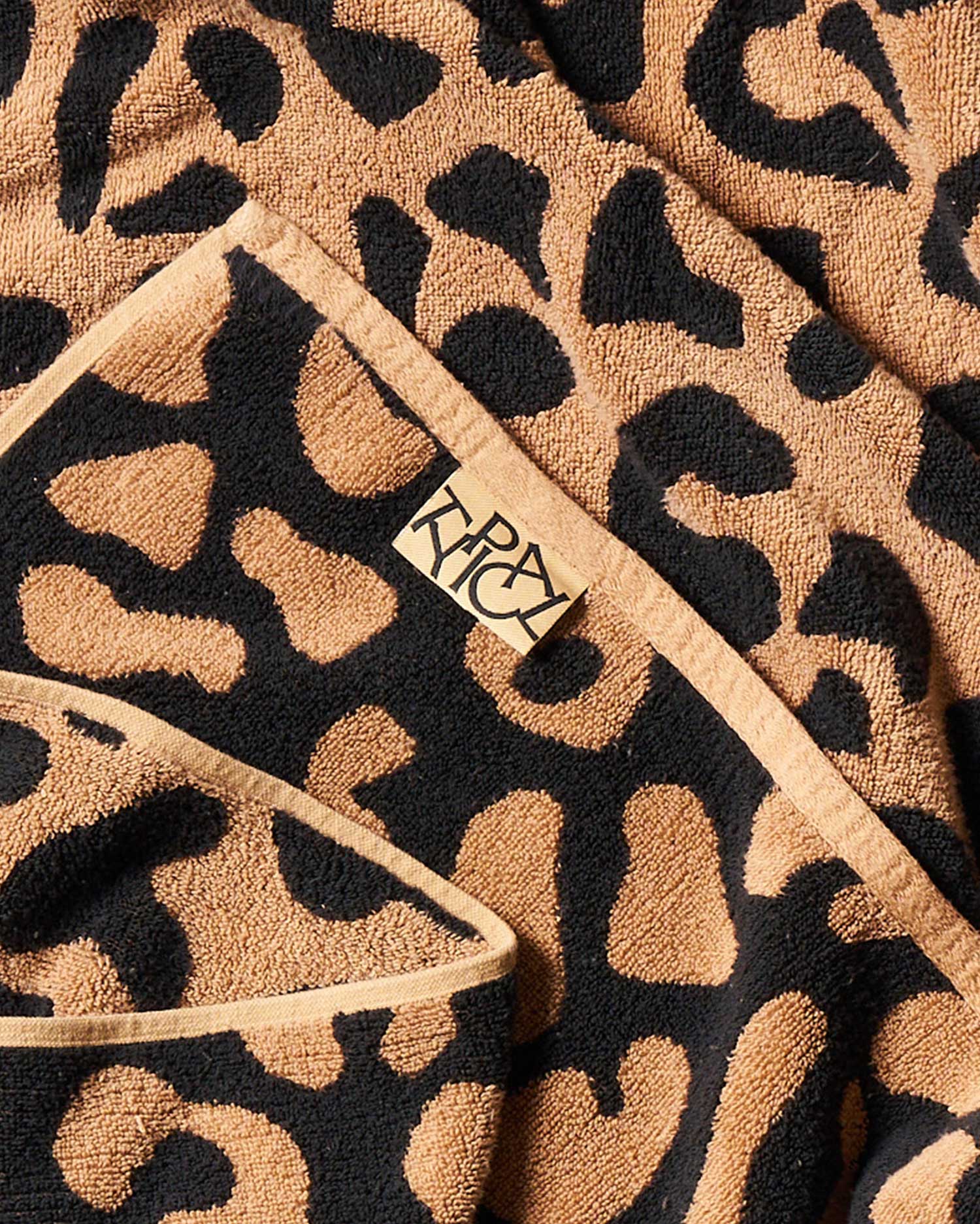 Leopard print towel with a brand logo on a beige background