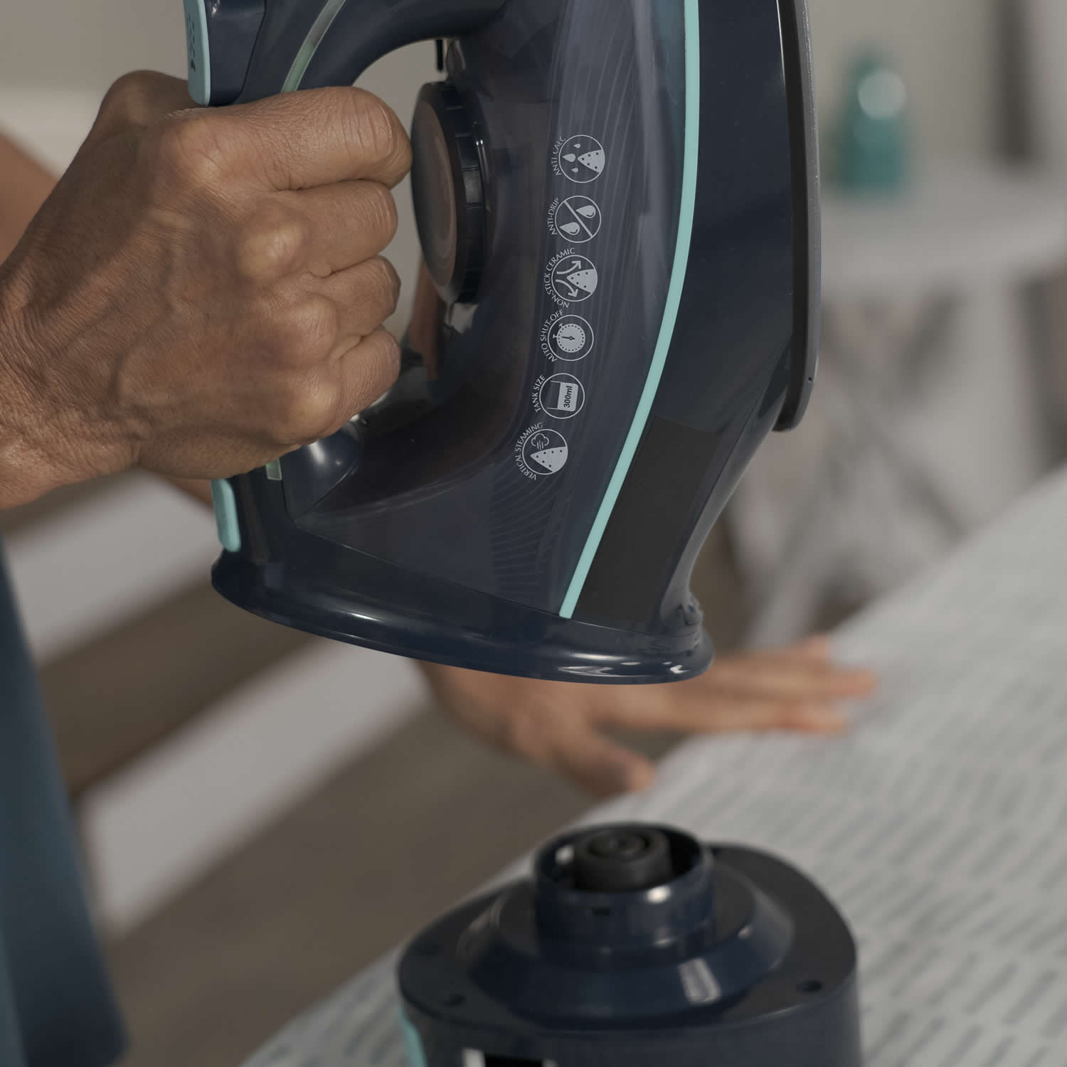 Person using a sewing machine with a focus on the hand and machine.