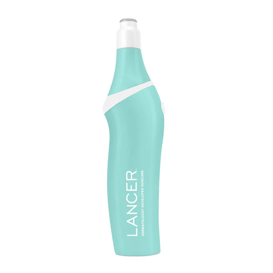 A person is using a pink microdermabrasion device on their leg in a bathroom setting.